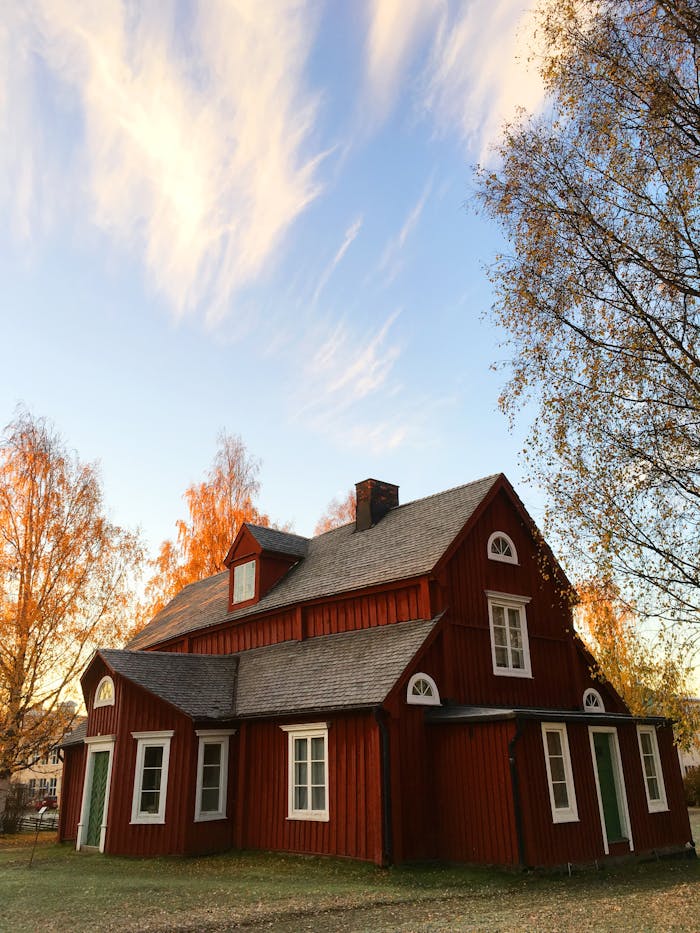 pexels-photo-210538 Picturesque red wooden house in autumn. Traditional Swedish architecture amidst colorful foliage.