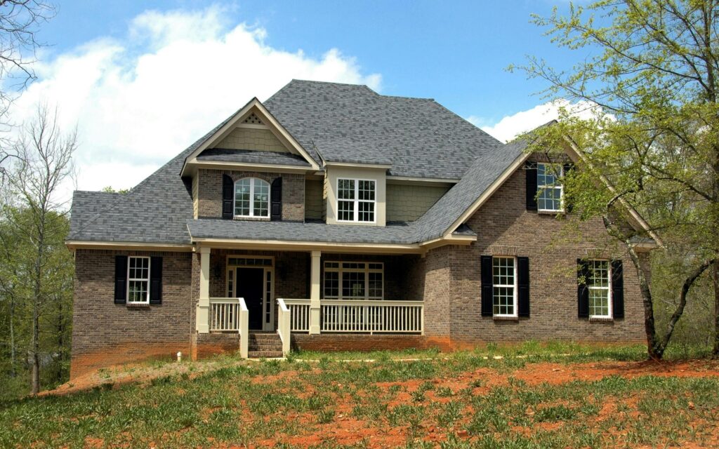 pexels-photo-209315-209315 Classic two-story brick house with gable roof and front lawn in suburban setting.